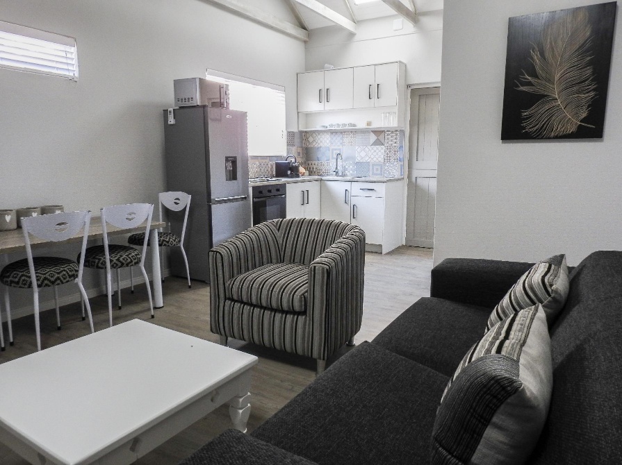 Self-catering group tour accommodation in Oudtshoorn with a fully equipped kitchen layout and family living area for school excursions, sports teams, and holidaymakers.