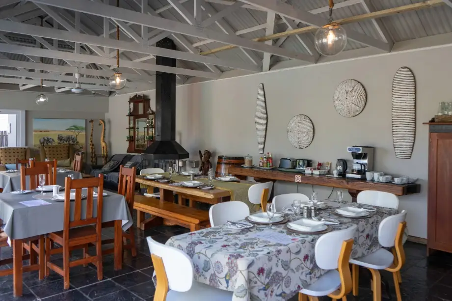 Communal breakfast station and group dining facilities featuring coffee makers and organized seating tables at a central Oudtshoorn estate.